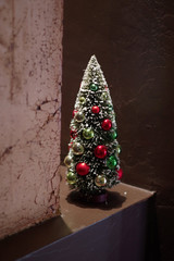 Decorative display with a small colorful artificial Christmas tree