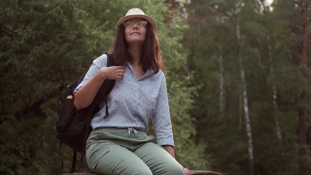 woman traveler resting in the forest. portrait of a young woman tourist in a hat outdoors