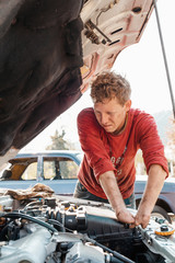 The concept of disability of people and their adaptation to life. Blond disabled man repairs the...