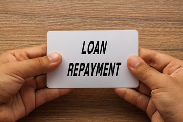 Loan Repayment written on white card holding with two hands