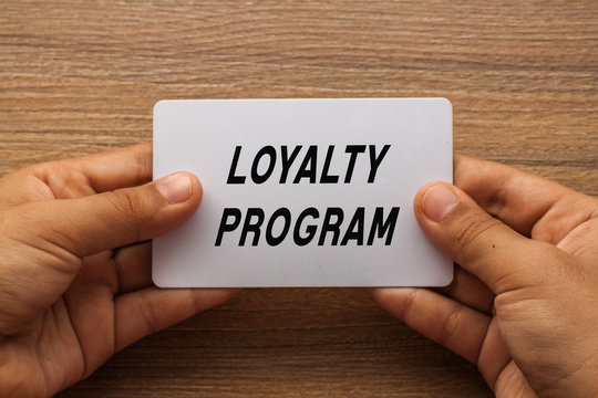 Loyalty Program written on white card holding with two hands
