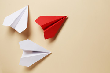 Flat lay of white paper airplanes and red paper airplane on background. Not like that....