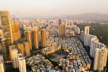 an aerial cityscape of shenzhen city, showcasing the "urban village" surrounded by high-up residential buildings