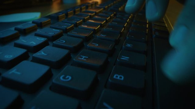 Close-up Moving Macro Shot: Person Typing on the Computer Keyboard finishing with Pressing Enter Button. Working, Writing Emails, Using Internet. Dark and Green Colors