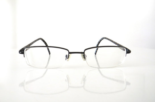 Close up modern style eyeglasses with transparent lenses isolated on white background with shadow.
