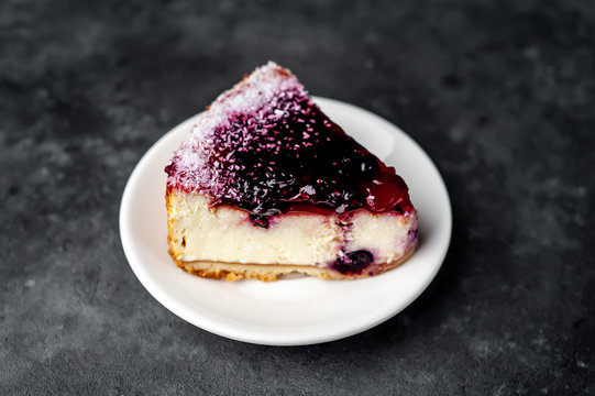 Currant cheesecake on a white plate on a stone background, ready to eat
