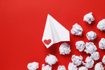 paper love airplane on red background..The concept of a love message. Valentine's Day. Declare...