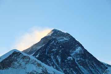 Naklejka premium Summit of Everest mountain in Himalayas just before sunrise. Colorful snow is blown away from the top. View from the slope of Kala Patthar mountain. Theme of travel in Nepal. Clear blue sky.