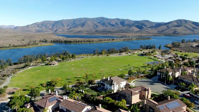 Aerial view of identical residential condo with big lake and mountain on the background during sunny day in Chula Vista, California, USA.