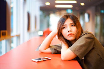 Lonely sad girl waiting for somebody and lying on the red table