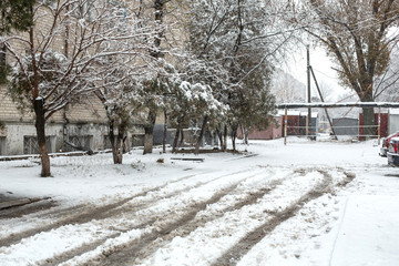 Fototapeta na wymiar Street covered with snow. Winter in the city. Dirt and slush.