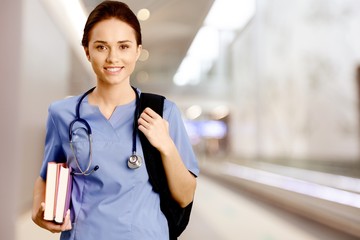 Young female doctor with stethoscope and books