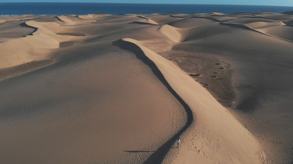 Aerial view - lonely girl standing on the sand, Maspalomas, Gran Canaria