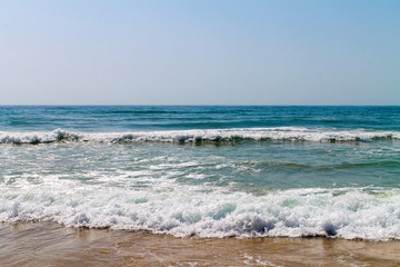 Fototapeta na wymiar Waves at the shore shot at bright sunny day