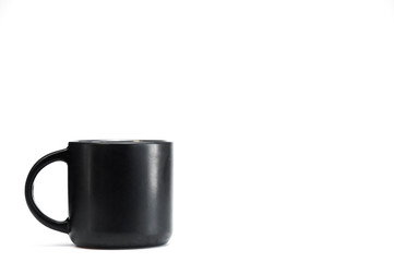 Black cup with tea or coffee on a white background.