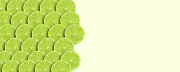 sliced green lime over yellow background, panoramic mock-up image, fresh fruit with space for text