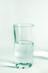 Pure clear water in a glass glass and glass jug stands on a white background