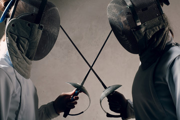 Duel. Fencers with fencing swords. Fencer competition concept.