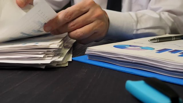 Close-up of hands holding papers. Office work with financial reports.