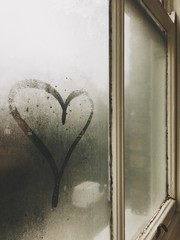 Heart in fog on window