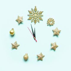 Christmas clock, dial, decorated with Christmas decorations, gold stars, bauble glitter, Christmas trees, creative flat composition with copy space, on neo mint background