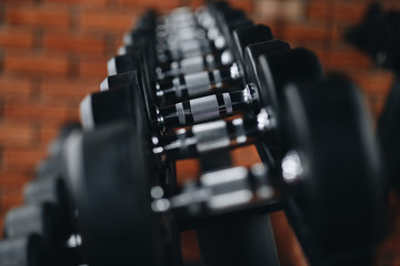 Naklejka premium arrow a lot of dumbbells in the gym against the background of a brick wall
