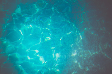 Blue water through which the sandy bottom is visible