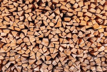 bois haché sec empilé dans un tas de bois, en arrière-plan