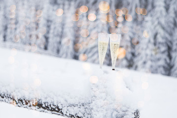 Naklejka na ściany i meble Champagne glasses in winter wonderland snow