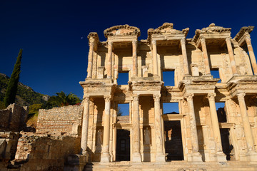 Ruins of the facade of the Library of Celsus with moon in blue sky at ancient city of Ephesus Turkey