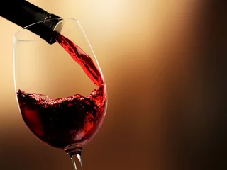 Foto op Plexiglas Giet rode wijn op onscherpe achtergrond © BillionPhotos.com