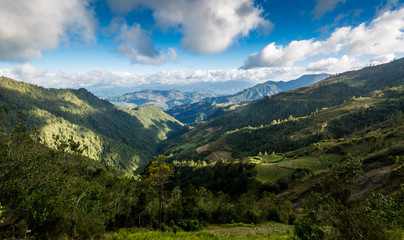 Fototapeta na wymiar dramatic landscape high in the caribean mountains of the dominican republic with clouds and blue sky.