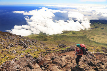 Young girl trekking and taking photos on Pico volcano (2351m) on Pico Island, Azores, Portugal,...