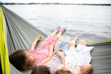 three girls on hammock by lake