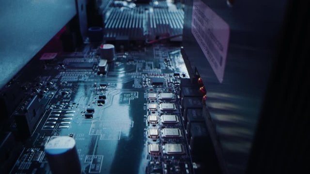 Macro Camera Moving Slowly over Printed Circuit Board, showing Computer Motherboard Components: Microchip, CPU Processor, Transistors. Inside of Electronic Device, Hardware. Neon Colors