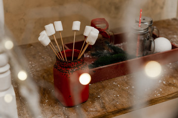 Christmas decor and garland. Cacao and marshmallow on the red tray