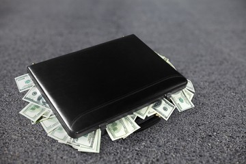 Money Bag with money on a stone floor.