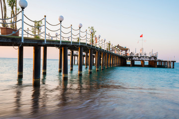 Fototapeta premium Empty wooden pier in the summer resort with festivity decoration