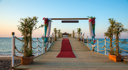 Empty wooden pier in the summer resort with festivity decoration