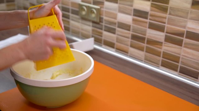 Grating lemon peel in the kitchen while preparing a cake dough for Christmas
