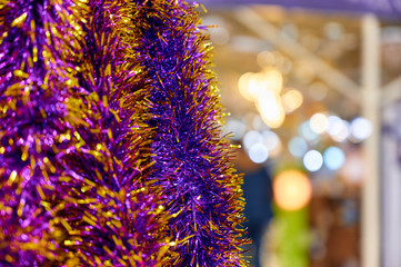 Photo of decoration from decorative multi-colored tinsel for the New Year and Christmas. Bright lights and colors, festive mood. The concept of a happy meeting of Christmas and New Year.