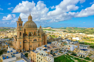 Fototapeta na wymiar Aerial view oа St. John Baptist Church. Countryside of Gozo island, cloudy blue sky. Europe. Malta 