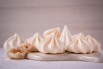 Fototapeta na wymiar Delicious homemade meringues on ceramic board. Sweet food. French dessert.