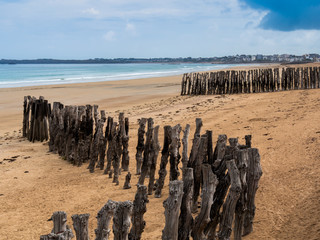 Two old wooden breakwaters on the coastline.