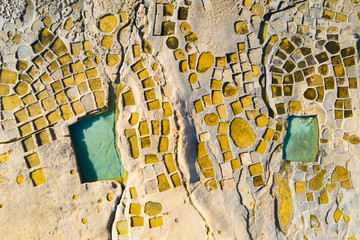 Salt pans on Gozo island. Blue sea and rocks. View from above, aerial. Close up. Malta country