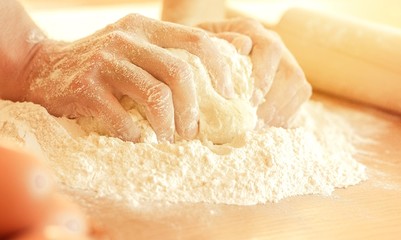 Human hand and flour on a kitchen desk
