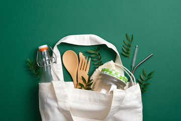 Reusable canvas shopper bag with eco friendly bamboo cutlery, metal drinking straws, glass jar and...