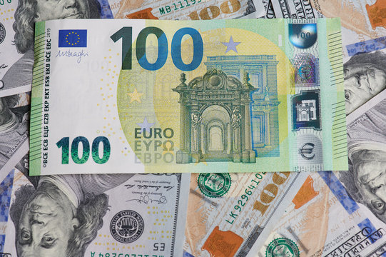 Hundred euro bill on dollar banknote background flat view