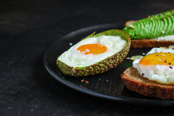 fried eggs in avocado (healthy food, vitamins) menu concept. food background. top view. copy space