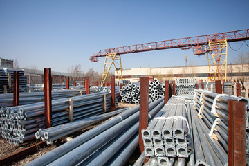 Naklejka premium Metal warehouse outdoor of lighting poles. Storage of metal galvanized faceted pipes with flange.